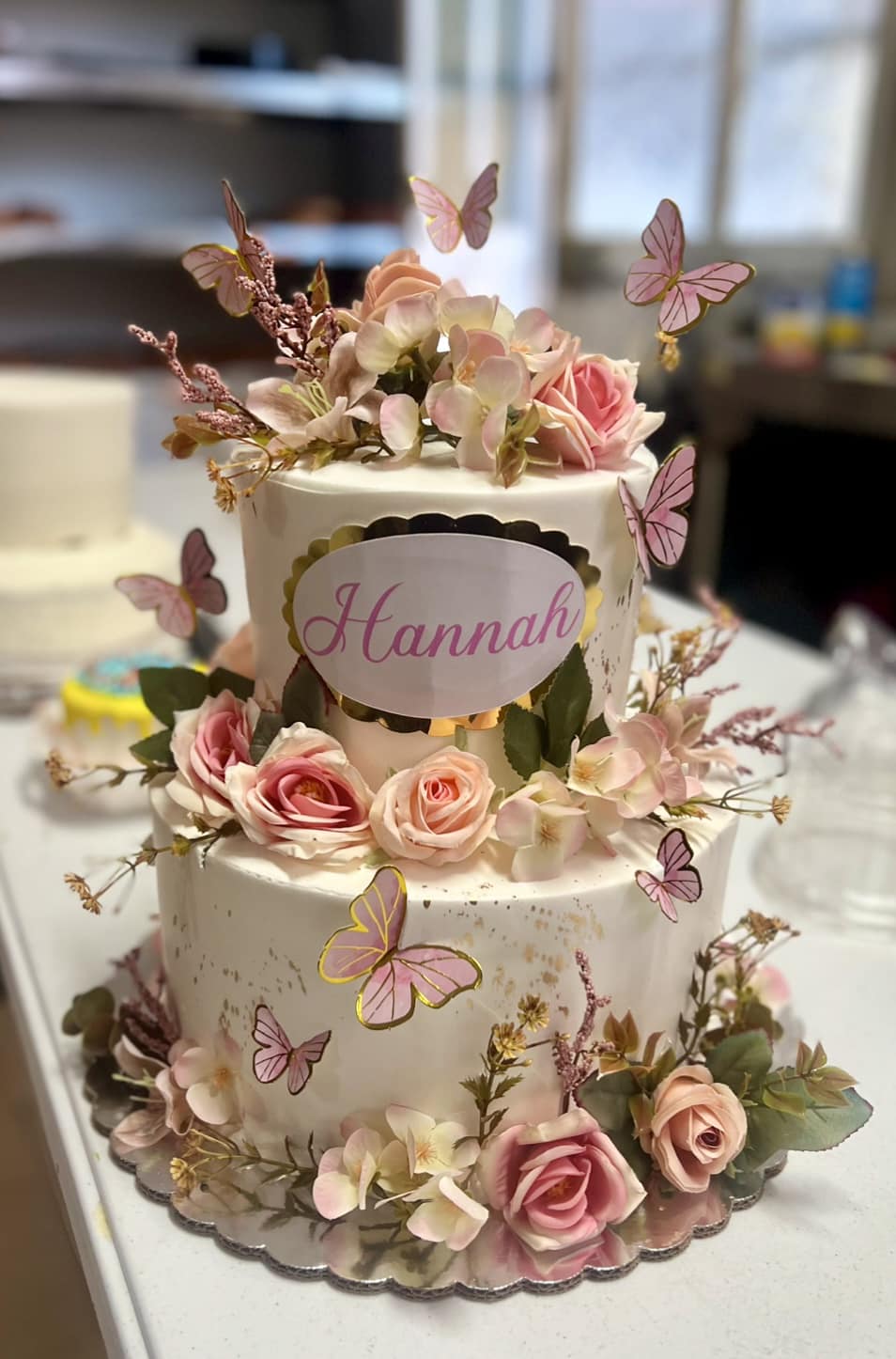Pastel de ensueño con delicadas mariposas y flores rosadas.